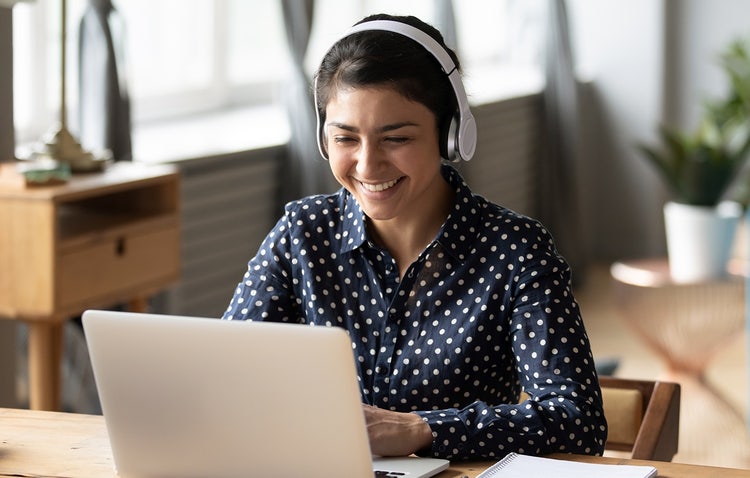 This image shows a student happily engaged with their laptop.