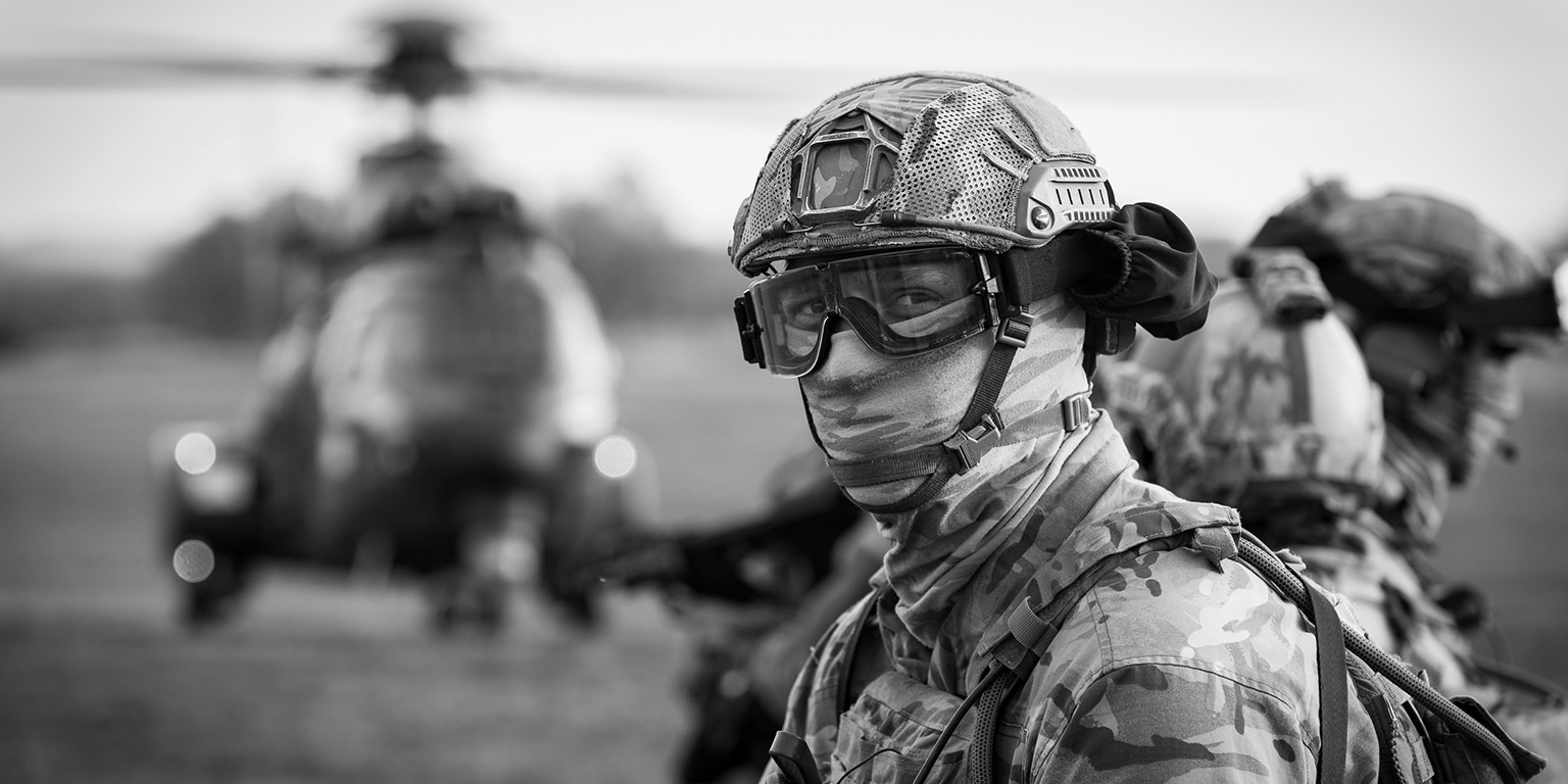 Soldier from the 16 Air Assault Brigade and 11e Brigade Parachutiste with other soldiers and helicopter in the background